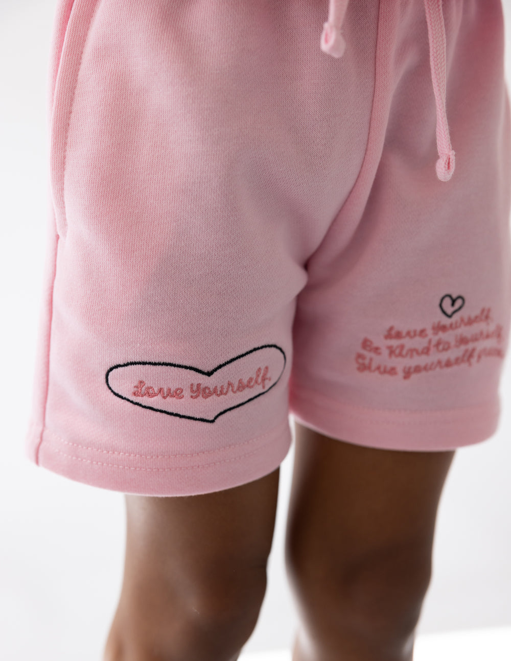 Kids pink shorts with heart cloud “Love Yourself” patch and small side script text