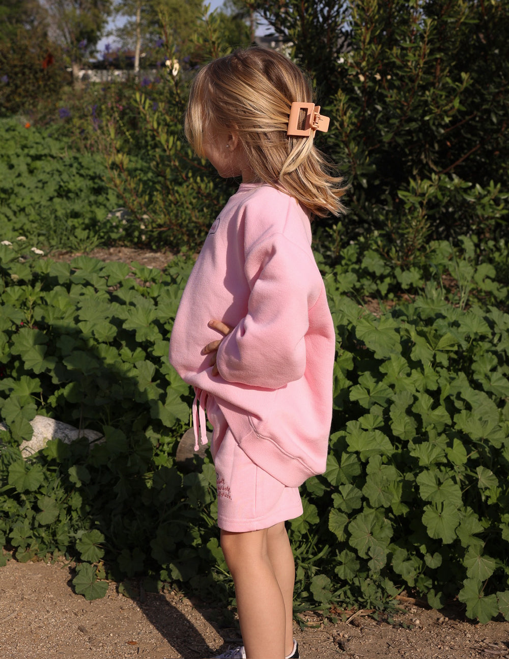 Kids pink shorts with drawstring waist and heart logo, shown from the back