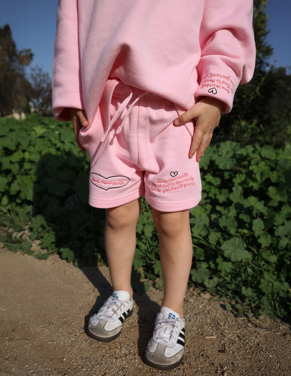 Kids pink shorts with heart graphic and drawstring waistband, front view