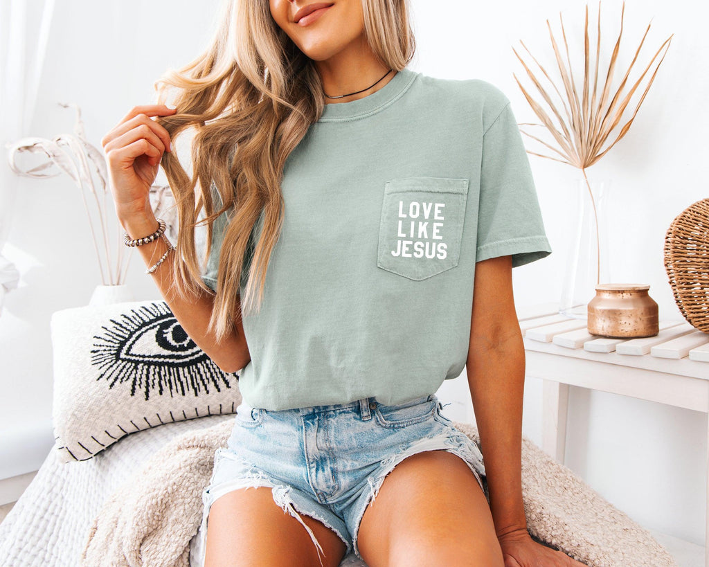 Short-sleeve pocket T-shirt, sage green, with “LOVE LIKE JESUS” logo on chest pocket.