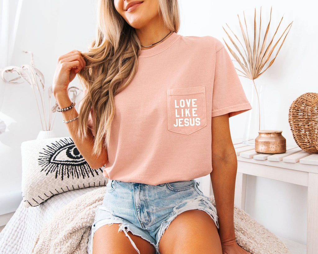 Short-sleeve pocket T-shirt, mauve-pink, with “LOVE LIKE JESUS” logo on chest.