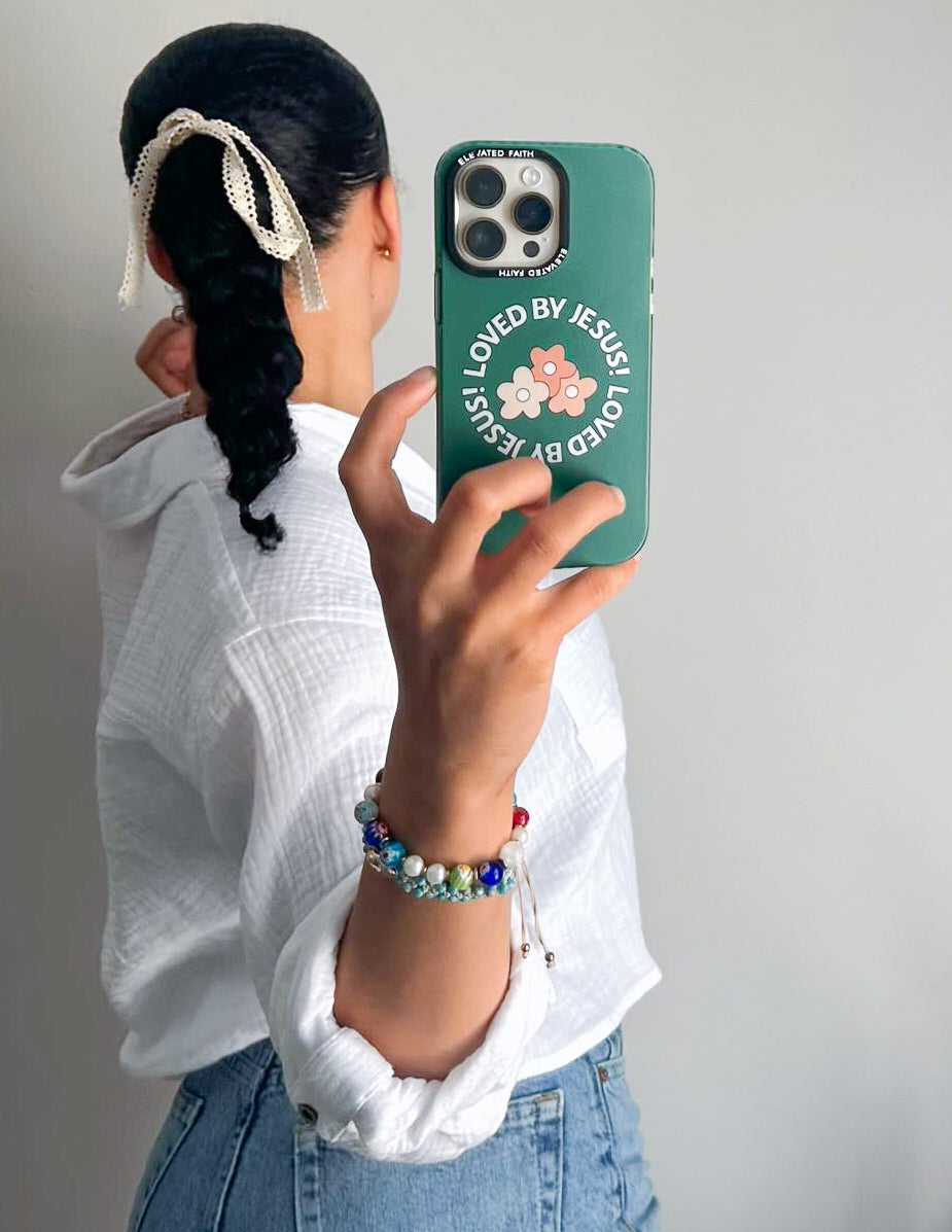 Green phone case with floral 'LOVED BY JESUS' design and camera lens openings