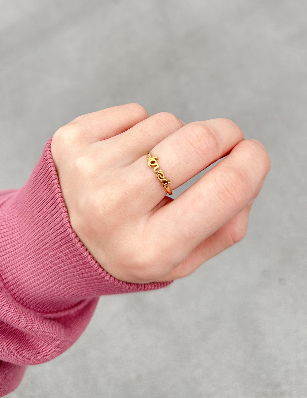 Gold-tone Loved ring with open-link design on finger