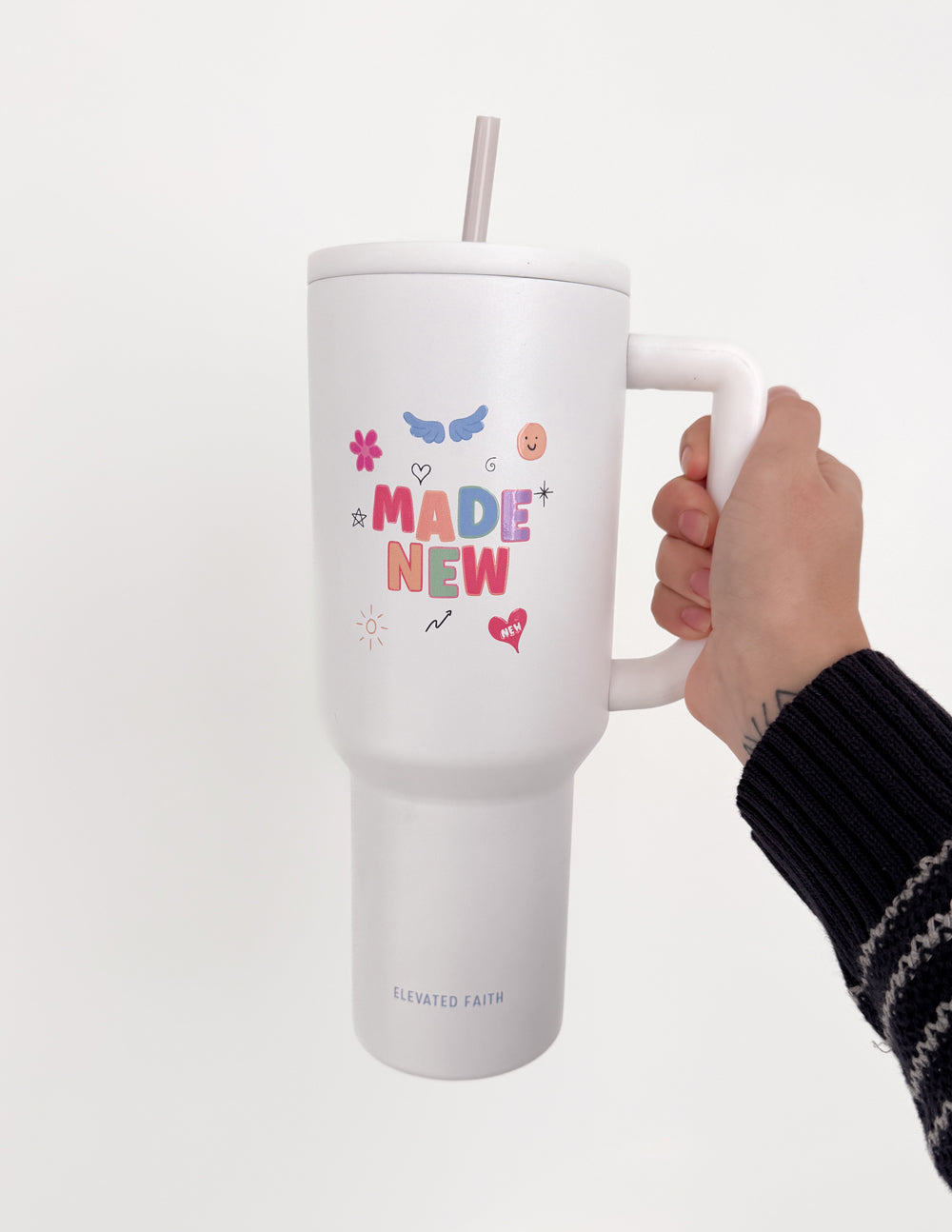 White 40 oz tumbler with handle and straw lid; hand gripping handle; “Made New” graphic