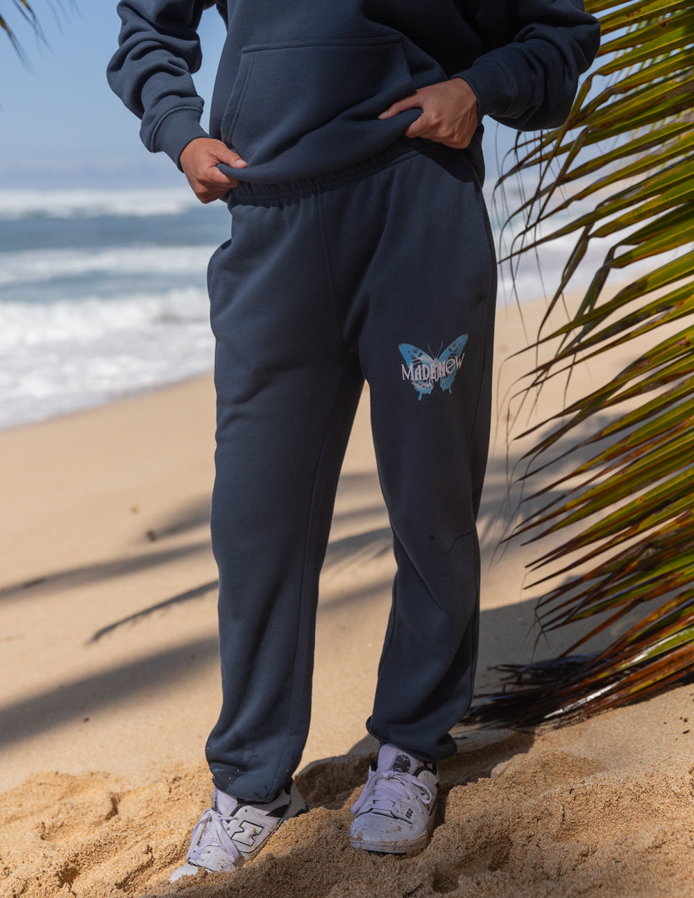 Navy unisex sweatpants with butterfly logo on thigh and elastic waistband and ankle cuffs