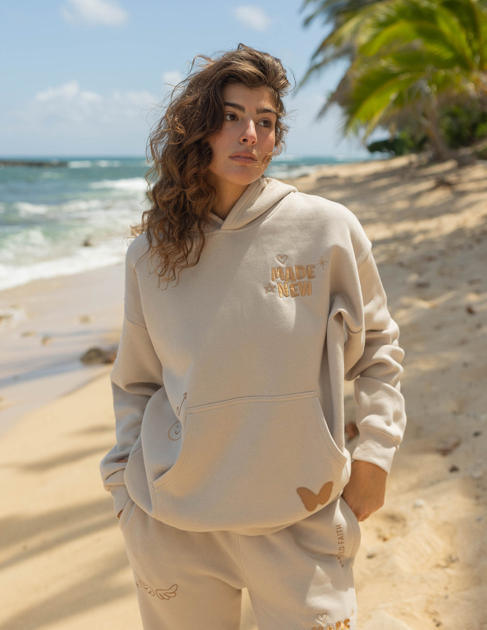 Cream unisex hoodie with hood, kangaroo pocket, and small printed chest logo