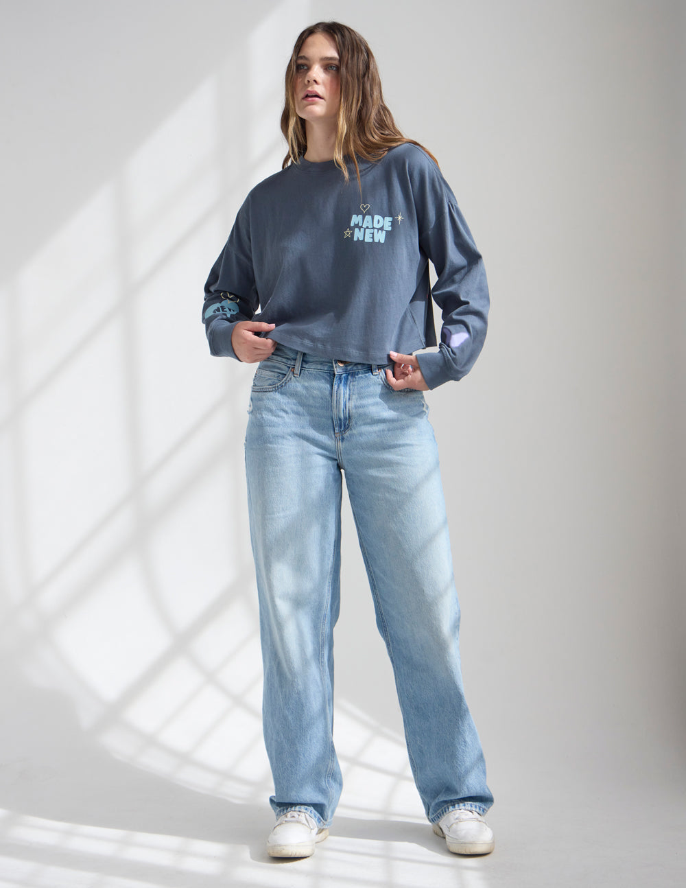 Cropped long-sleeve women’s tee in dark blue with “Made New” graphic on chest
