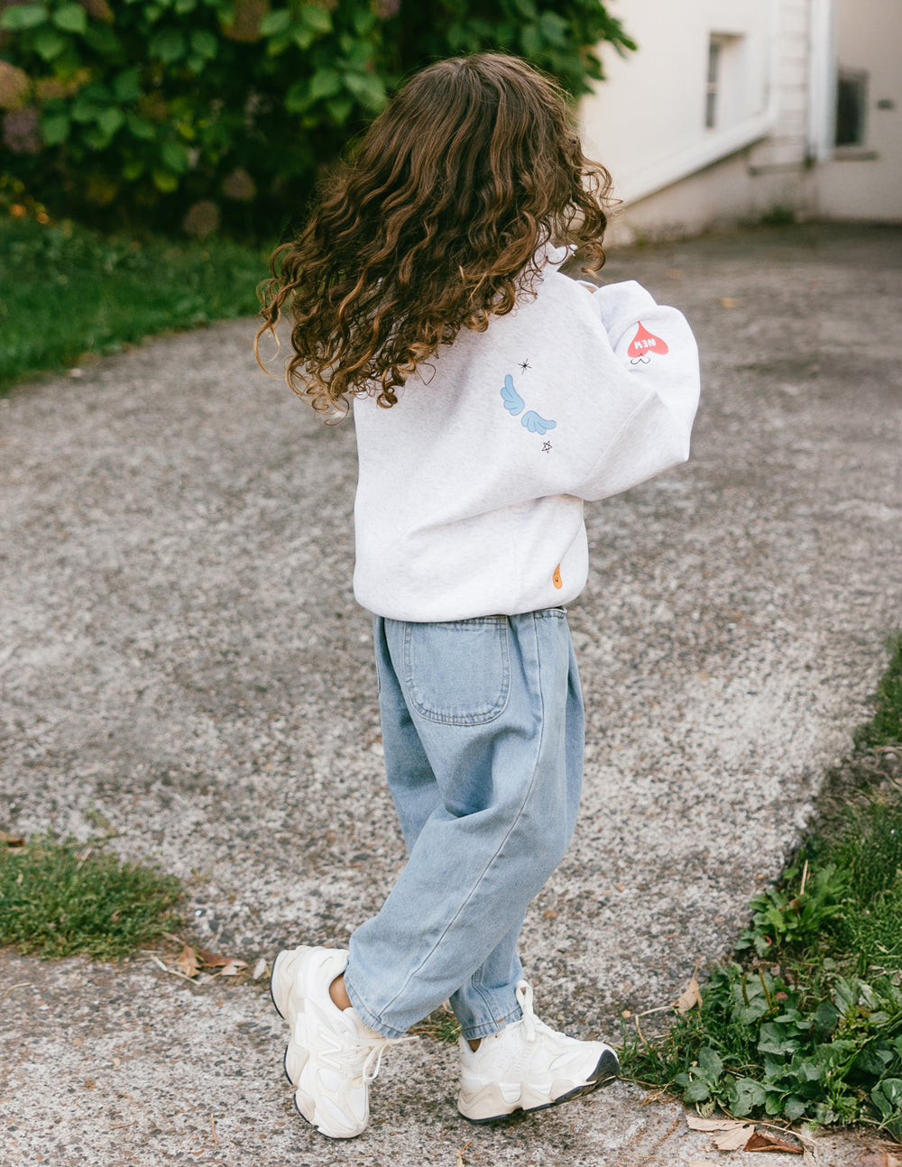 Kids gray half-zip sweatshirt with long sleeves and chest logo, side view