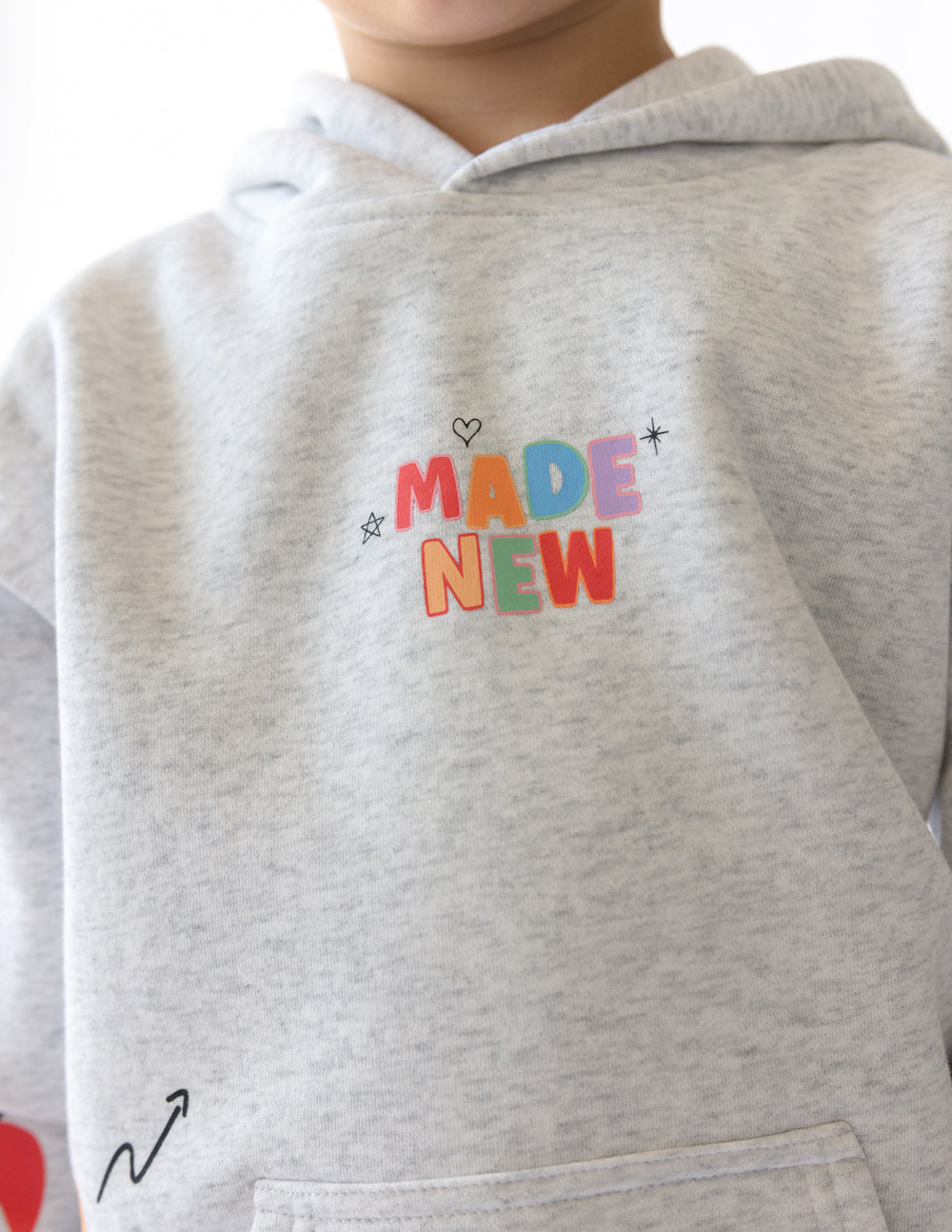 Kids light gray hoodie close-up of colorful chest graphic and hood opening