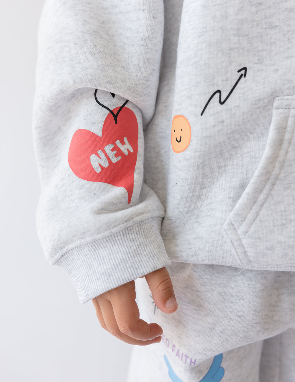 Kids light gray hoodie sleeve with heart-shaped Made New graphic and long cuffs