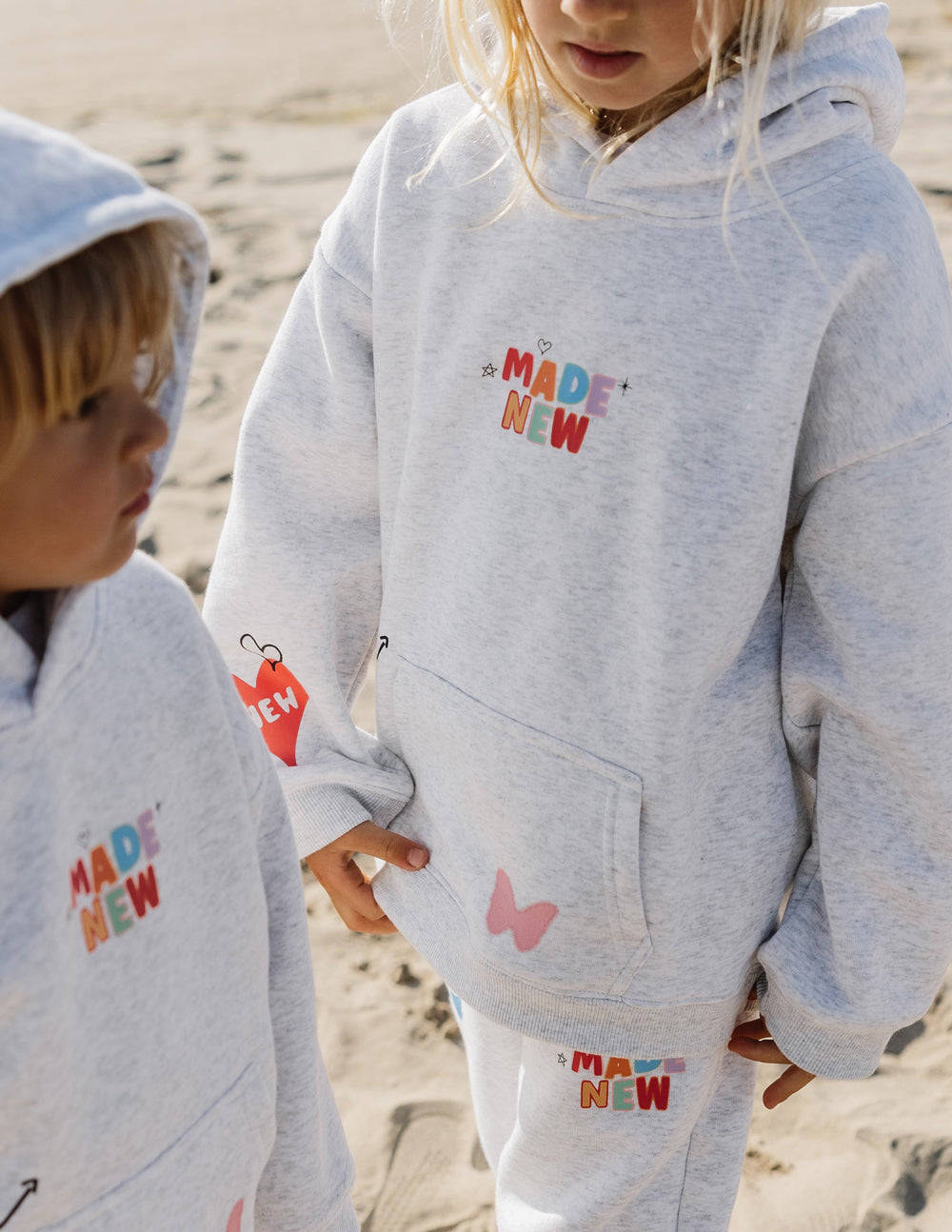 Kids light gray hoodie with hood, kangaroo pocket, and Made New logo on chest