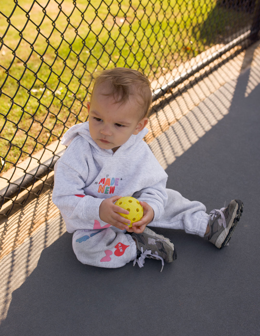 Kids light gray hoodie with colorful front graphic and long sleeves