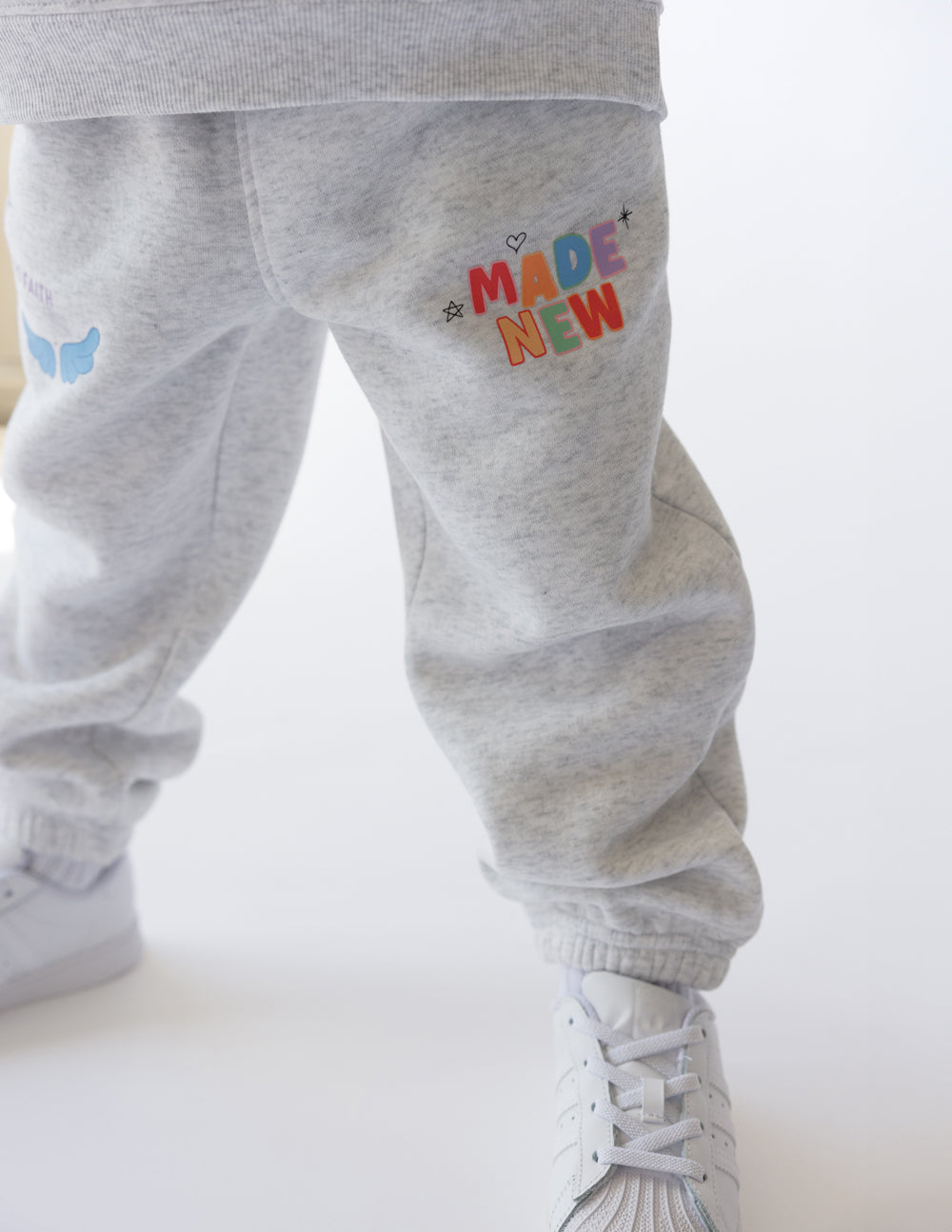 Kids gray sweatpants with elastic cuffs and 'MADE NEW' graphic on thigh