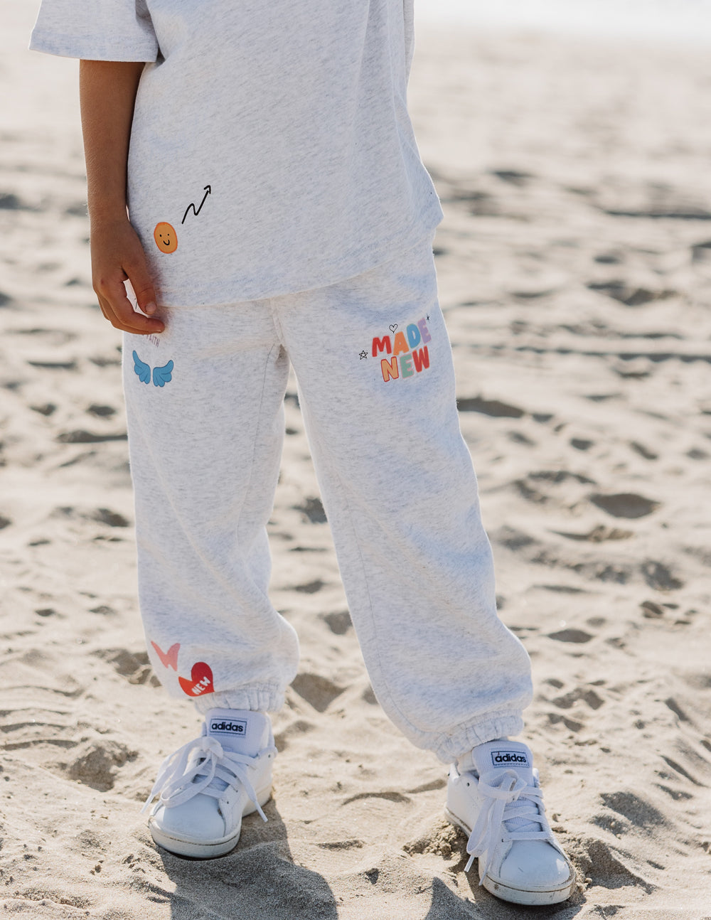 Kids gray sweatpants with elastic cuff hems and 'MADE NEW' patch on leg