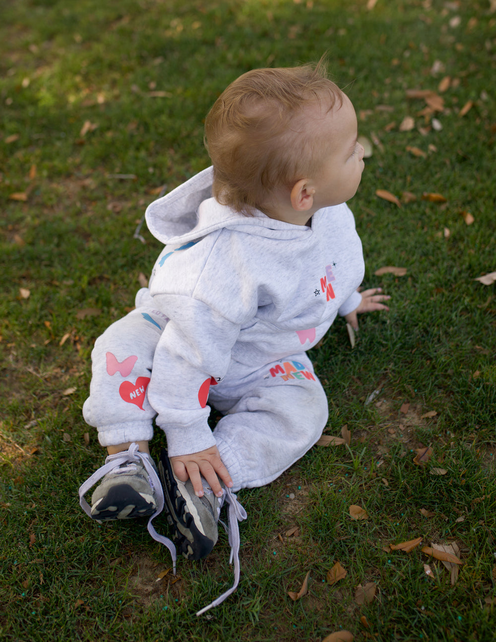 Kids gray sweatpants with elastic cuffs and 'MADE NEW' heart graphic