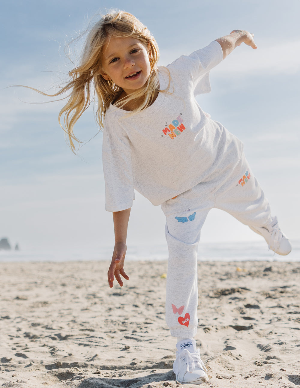 Kids grey long-sleeve tee with small 'MADE NEW' print and heart graphics