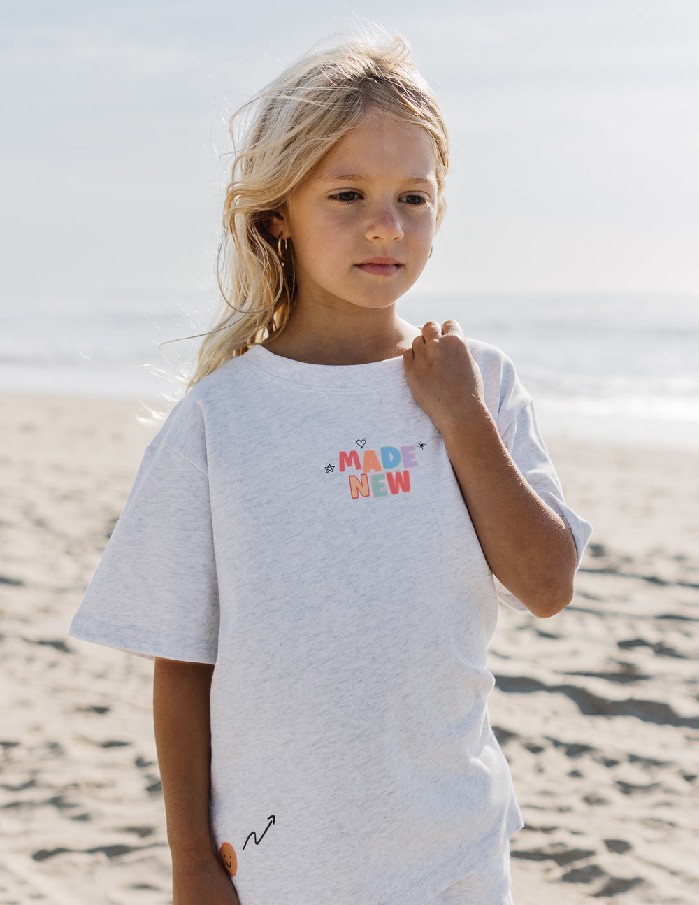 Kids grey graphic tee with 'MADE NEW' chest text and small heart accents