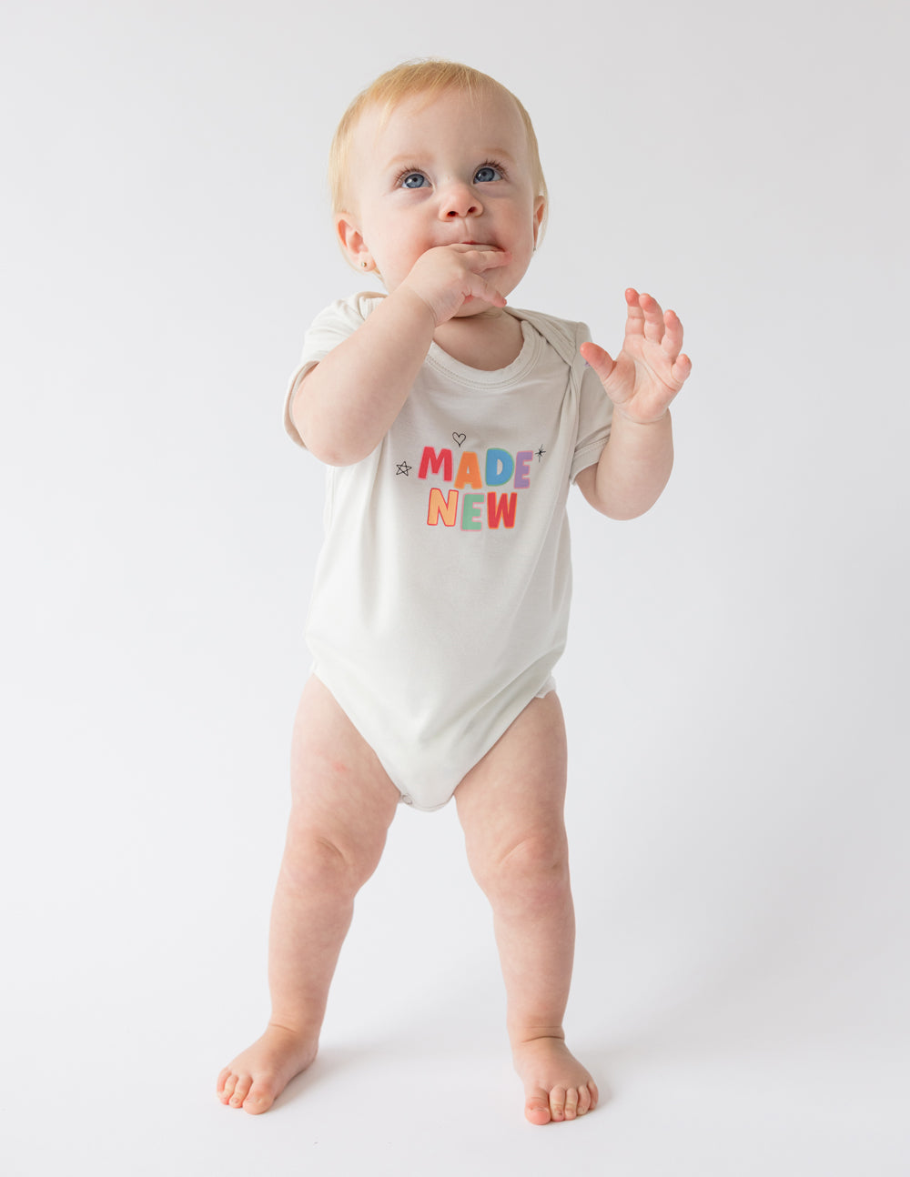 White baby onesie with short sleeves and "MADE NEW" graphic