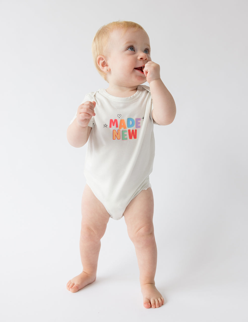 White baby onesie with "MADE NEW" graphic, short sleeves