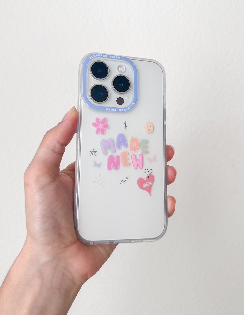 Light blue outline phone case with 'MADE NEW' graphic and icons, held in hand