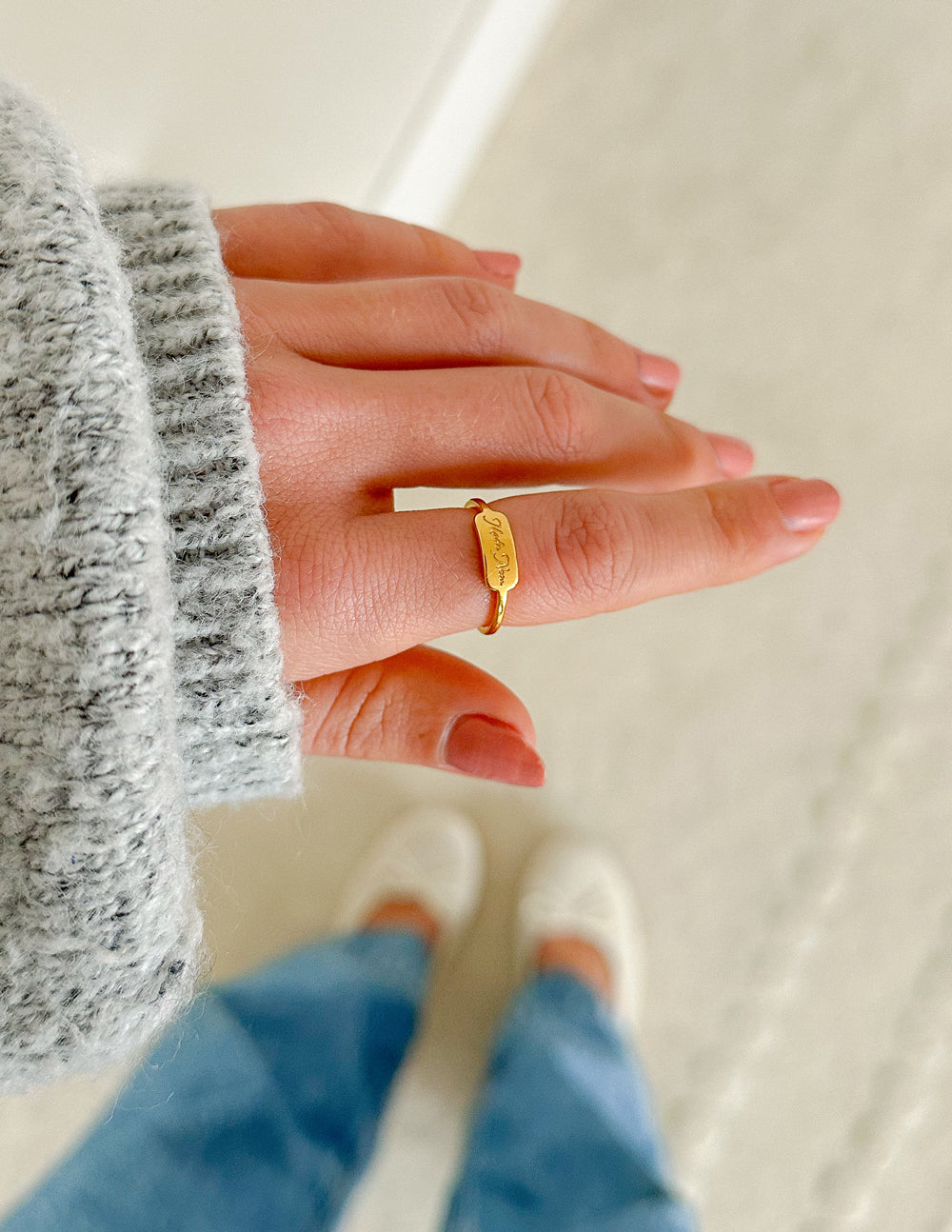 Gold engraved band ring with small raised detail on finger