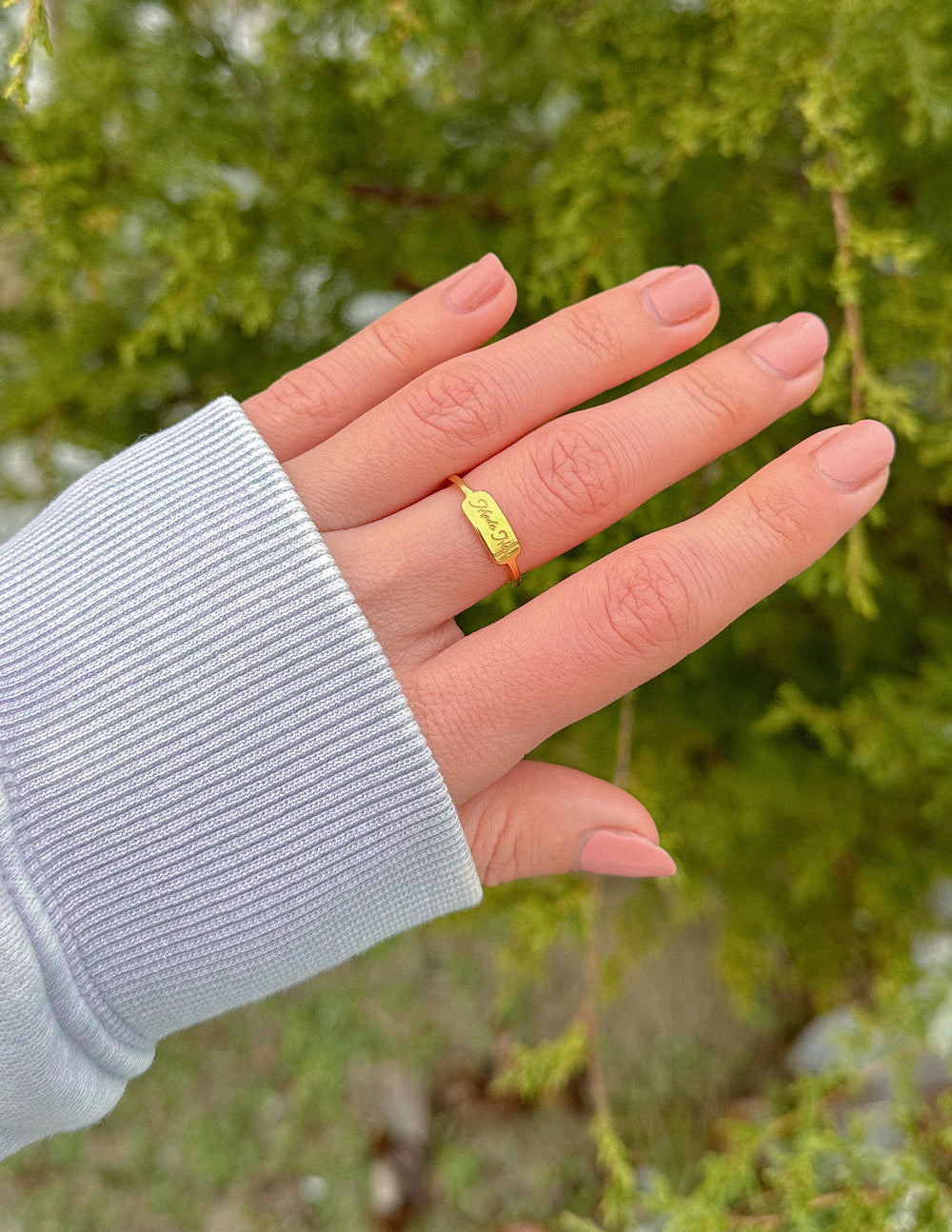 Gold engraved band ring on finger