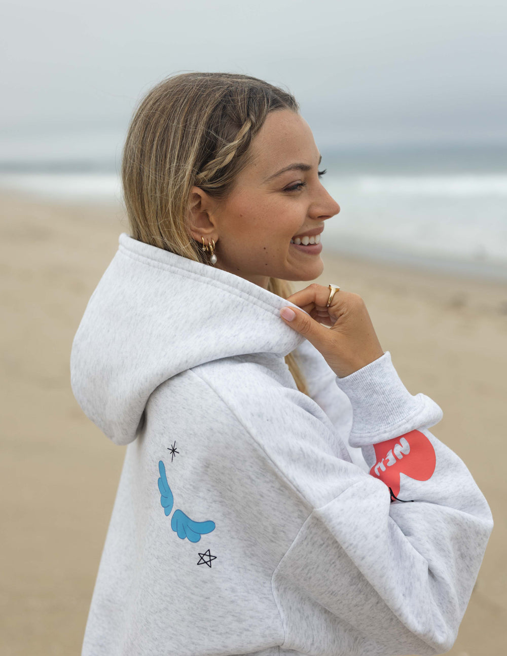 Light gray unisex hoodie with colorful heart graphic on sleeve and drawstring hood