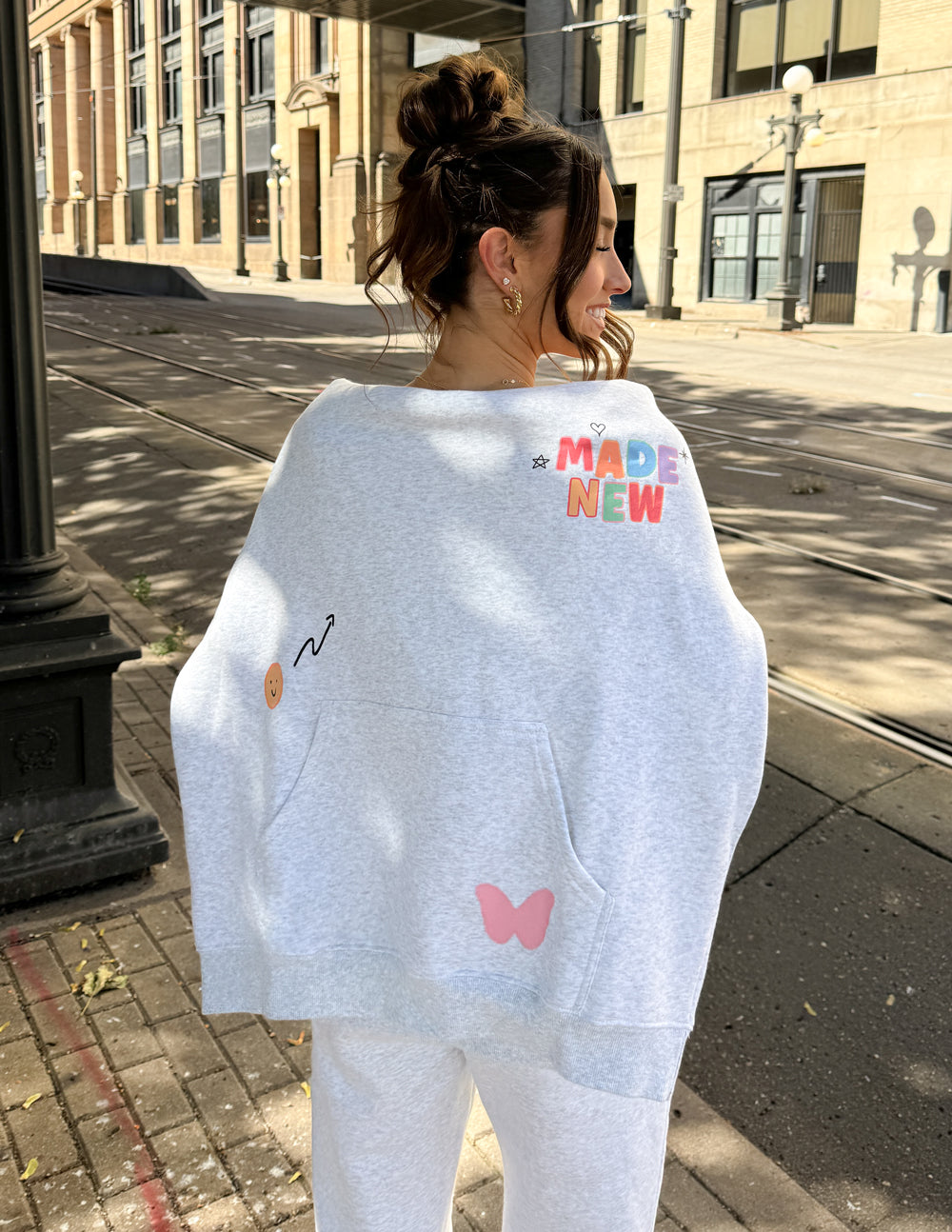 Light gray unisex hoodie with colorful back print and hood, relaxed fit