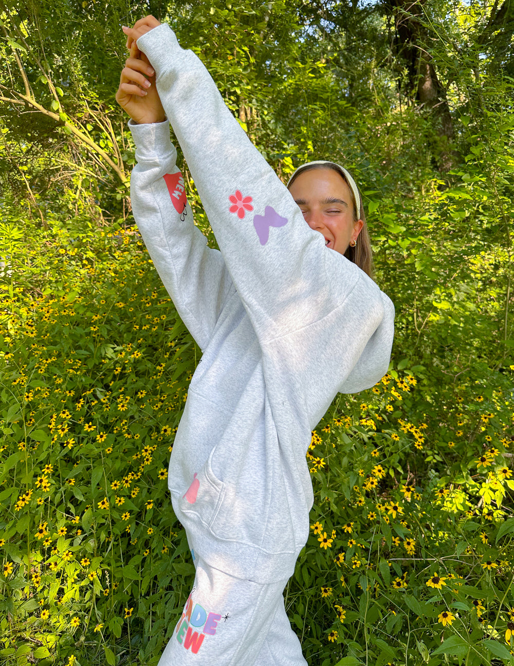 Light gray unisex hoodie with hood, front pouch pocket, colorful "Made New" print
