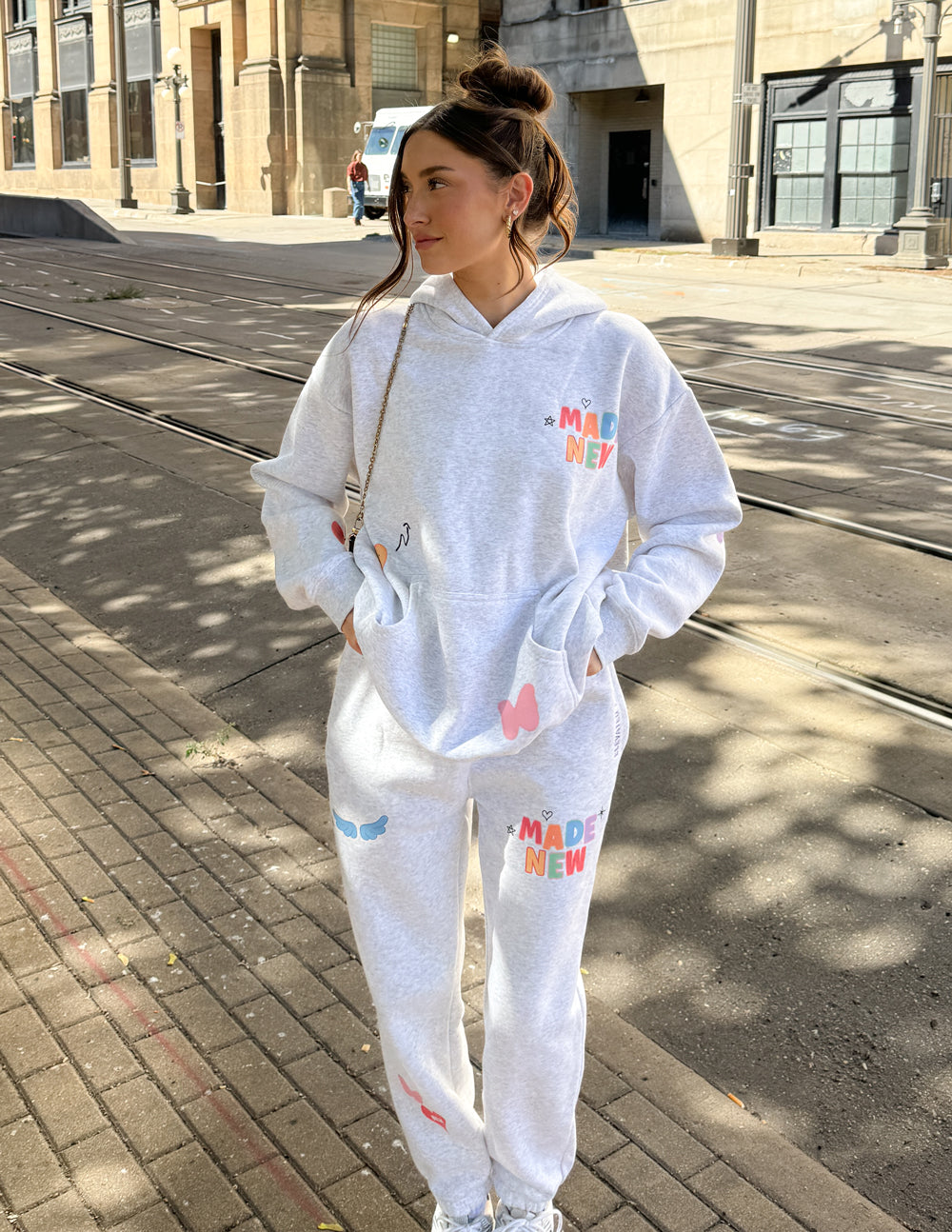 Light gray unisex hoodie with colorful chest logo and kangaroo pocket