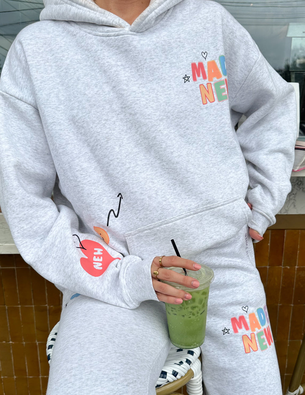 Light gray unisex hoodie with colorful logo chest graphic and kangaroo pocket