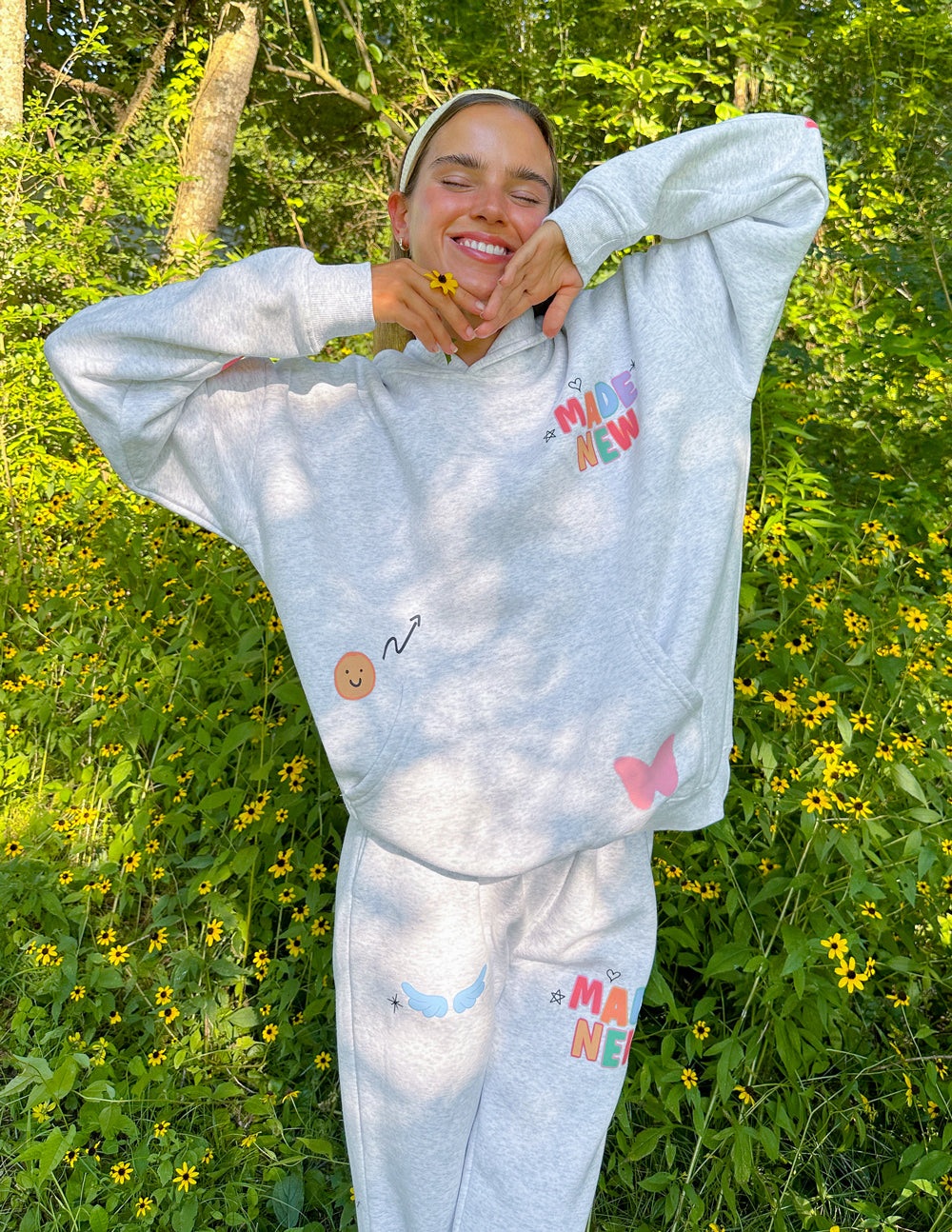 Heather gray sweatpants with colorful heart, flower, and "Made New" logo prints