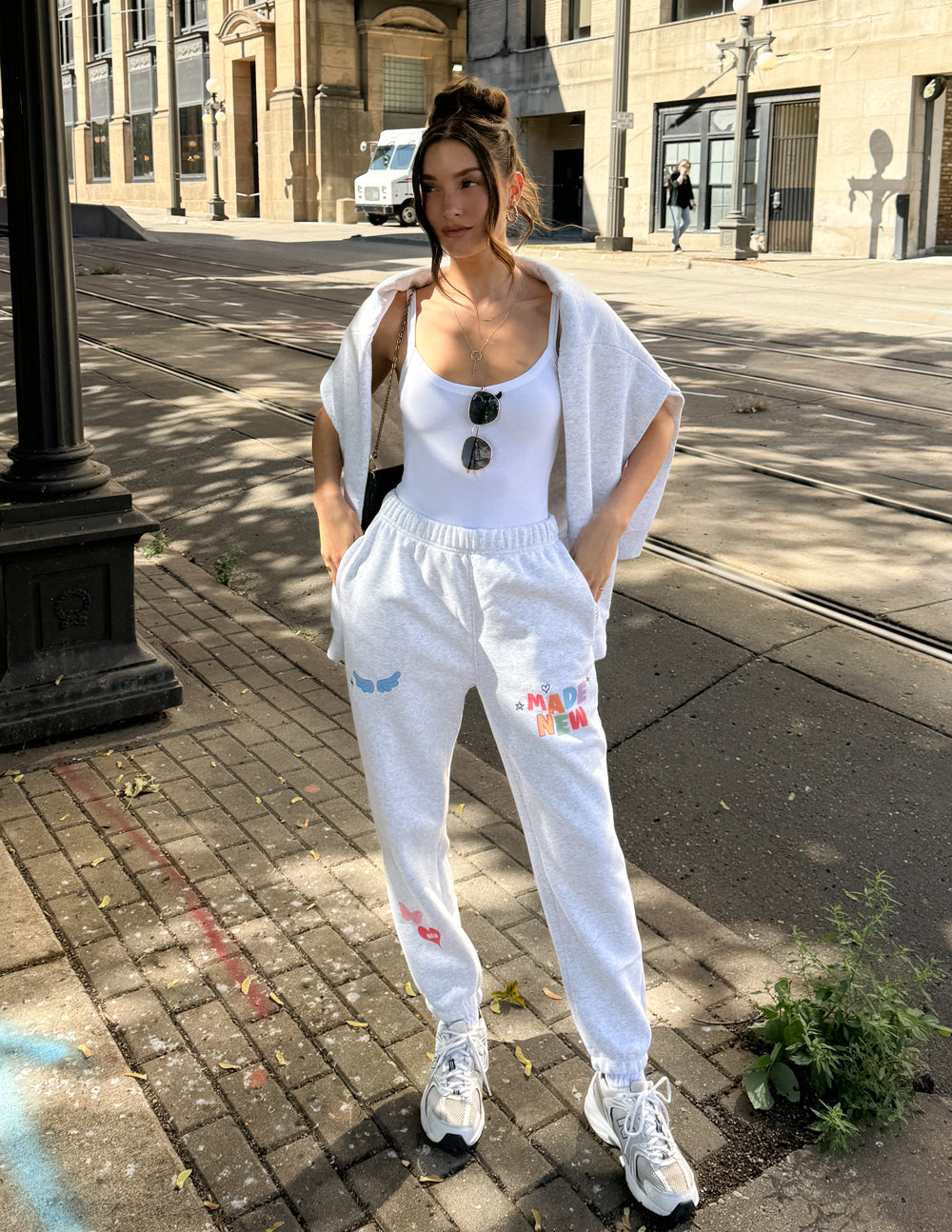 Heather gray unisex sweatpants with "Made New" logo and small heart and wing prints