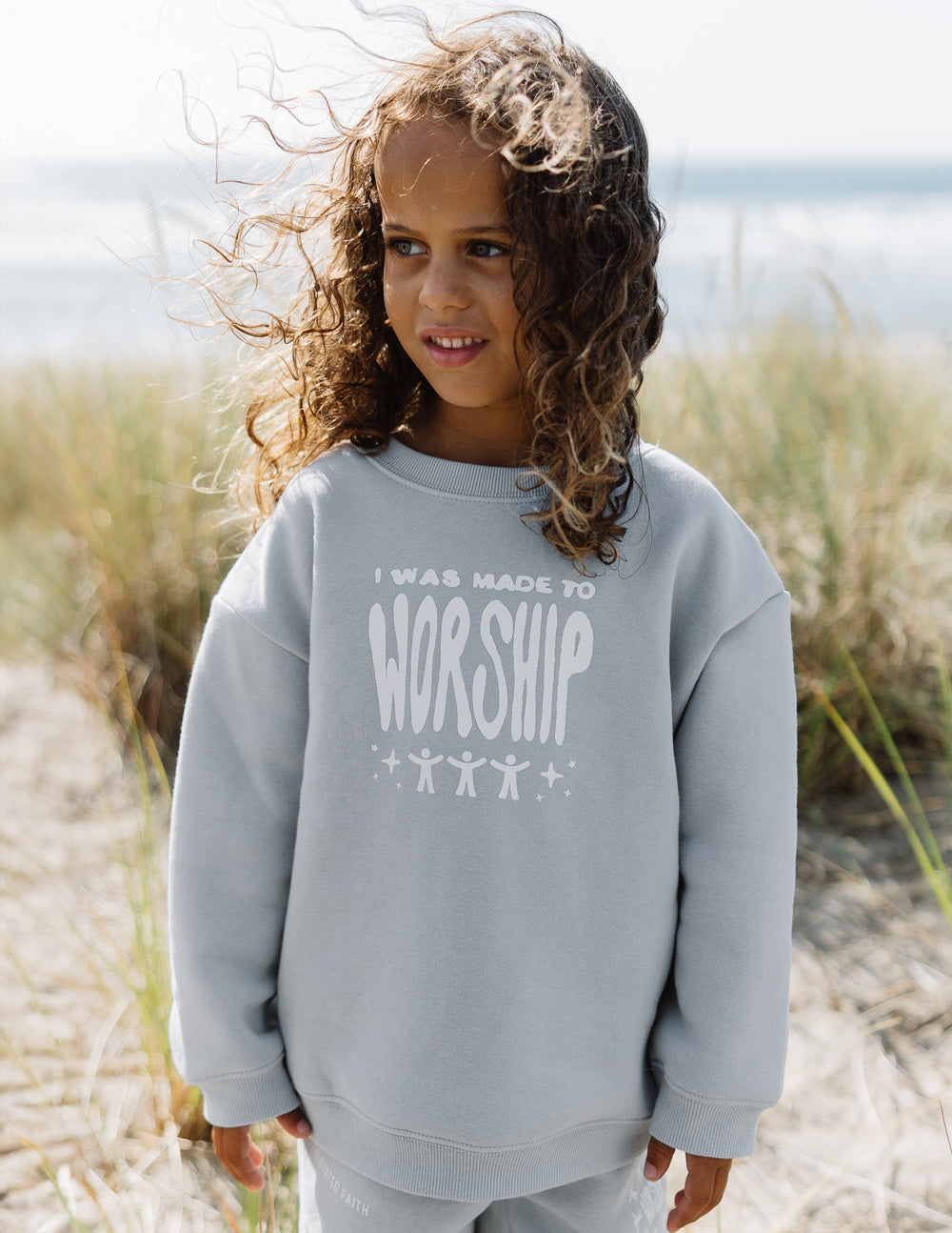 Kids crewneck sweatshirt, light blue; chest “worship” graphic, crew neckline