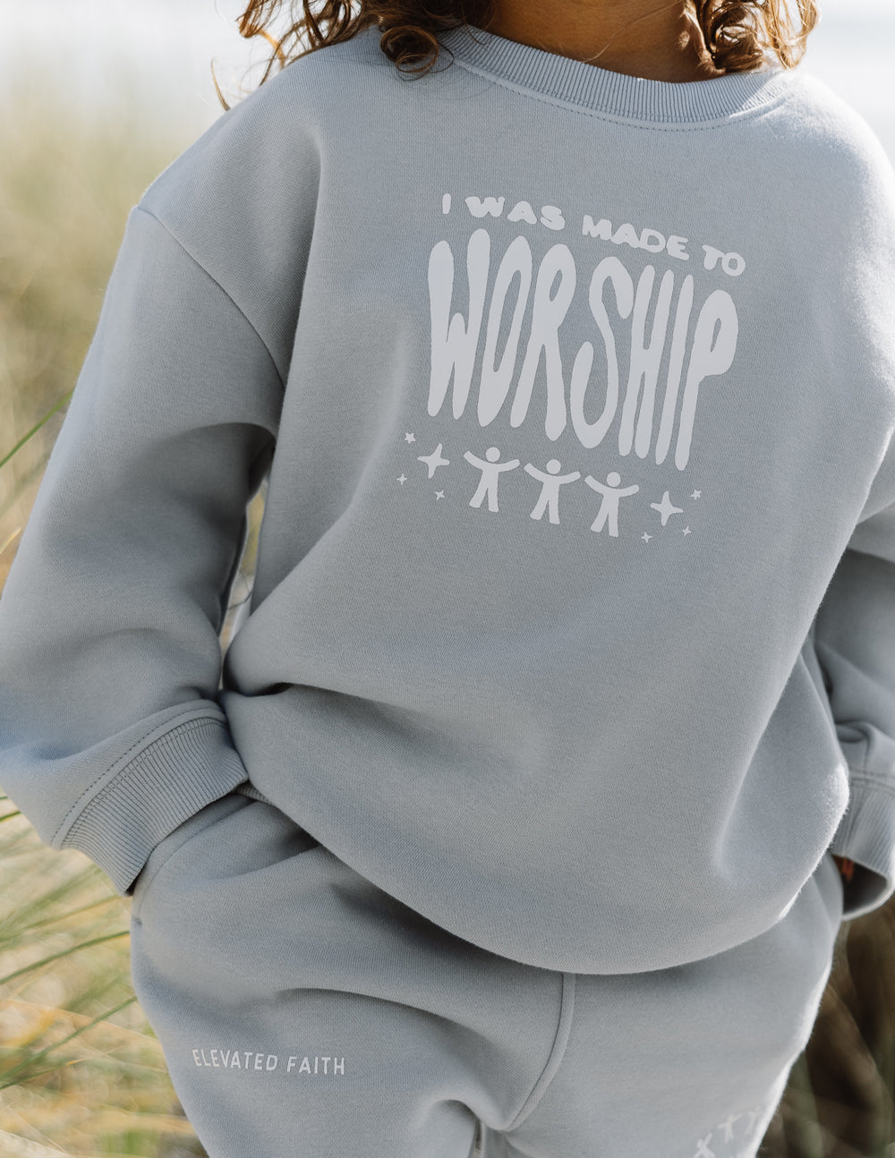 Kids crewneck sweatshirt, light blue with “worship” graphic on back