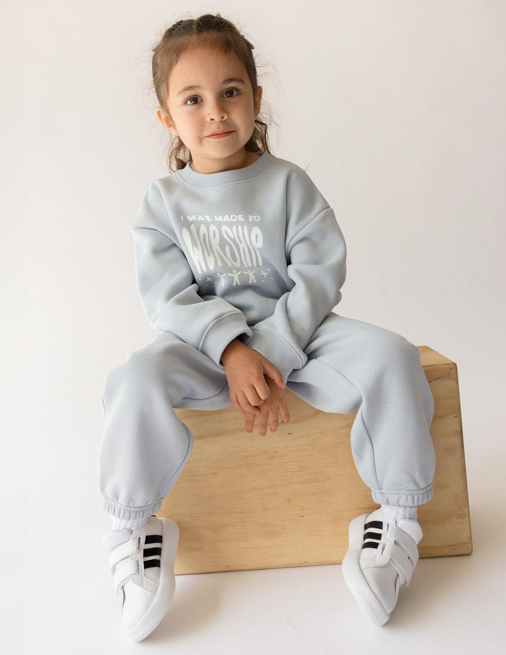 Kids crewneck sweatshirt, light blue; front “worship” graphic, relaxed fit sleeves