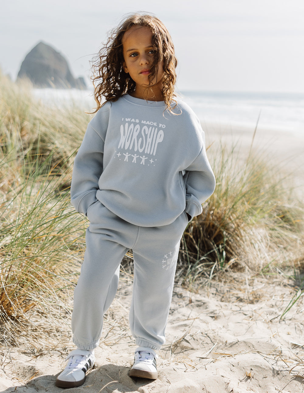 Kids light blue sweatpants with elastic waist and graphic on leg, cuffed hem