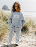 Kids light blue sweatpants with elastic waist and graphic on leg, cuffed hem
