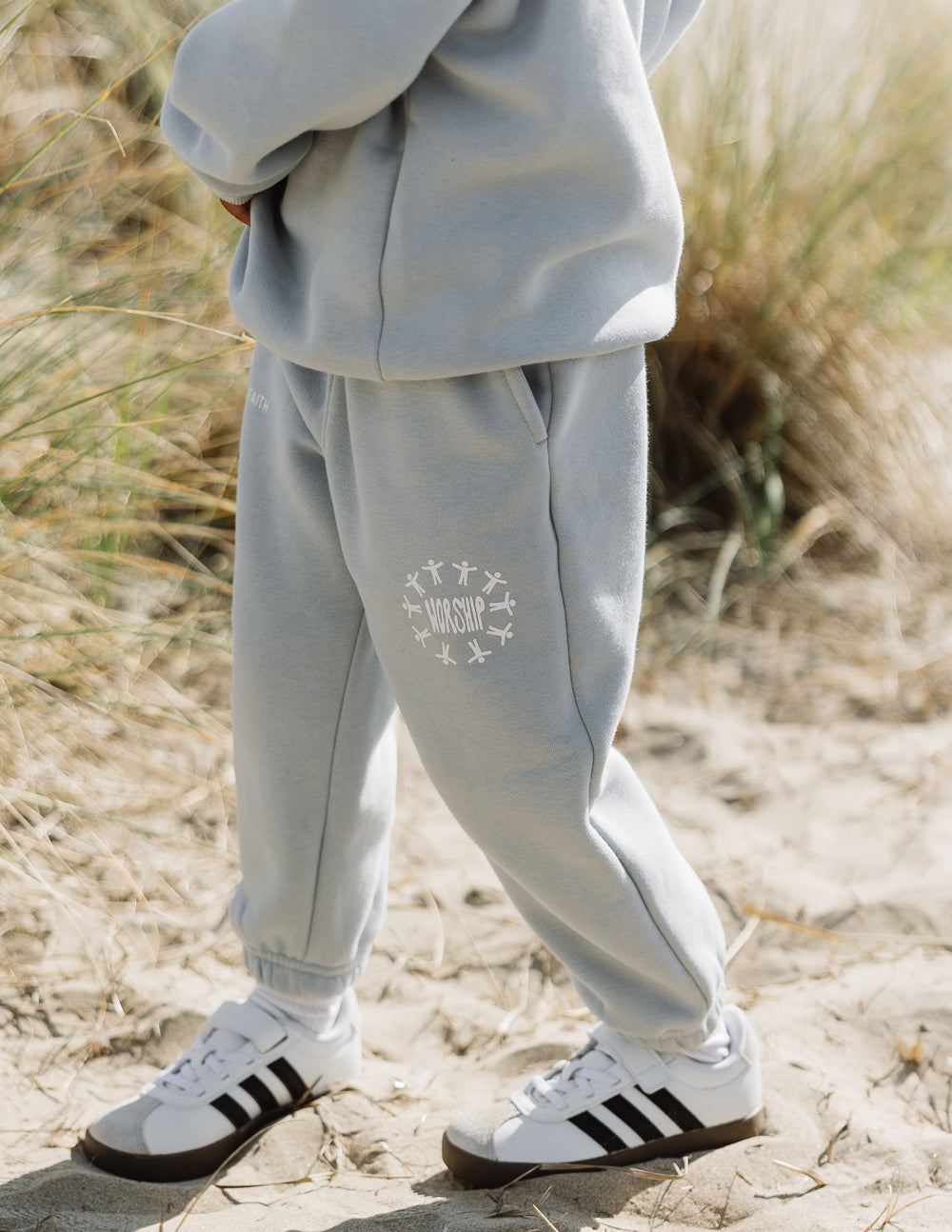 Kids light blue sweatpants with circular logo graphic and cuffed ankle