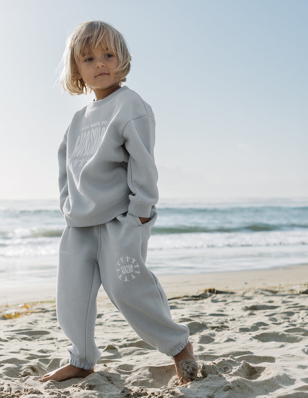 Kids light blue sweatpants with elastic cuffs and small leg graphic