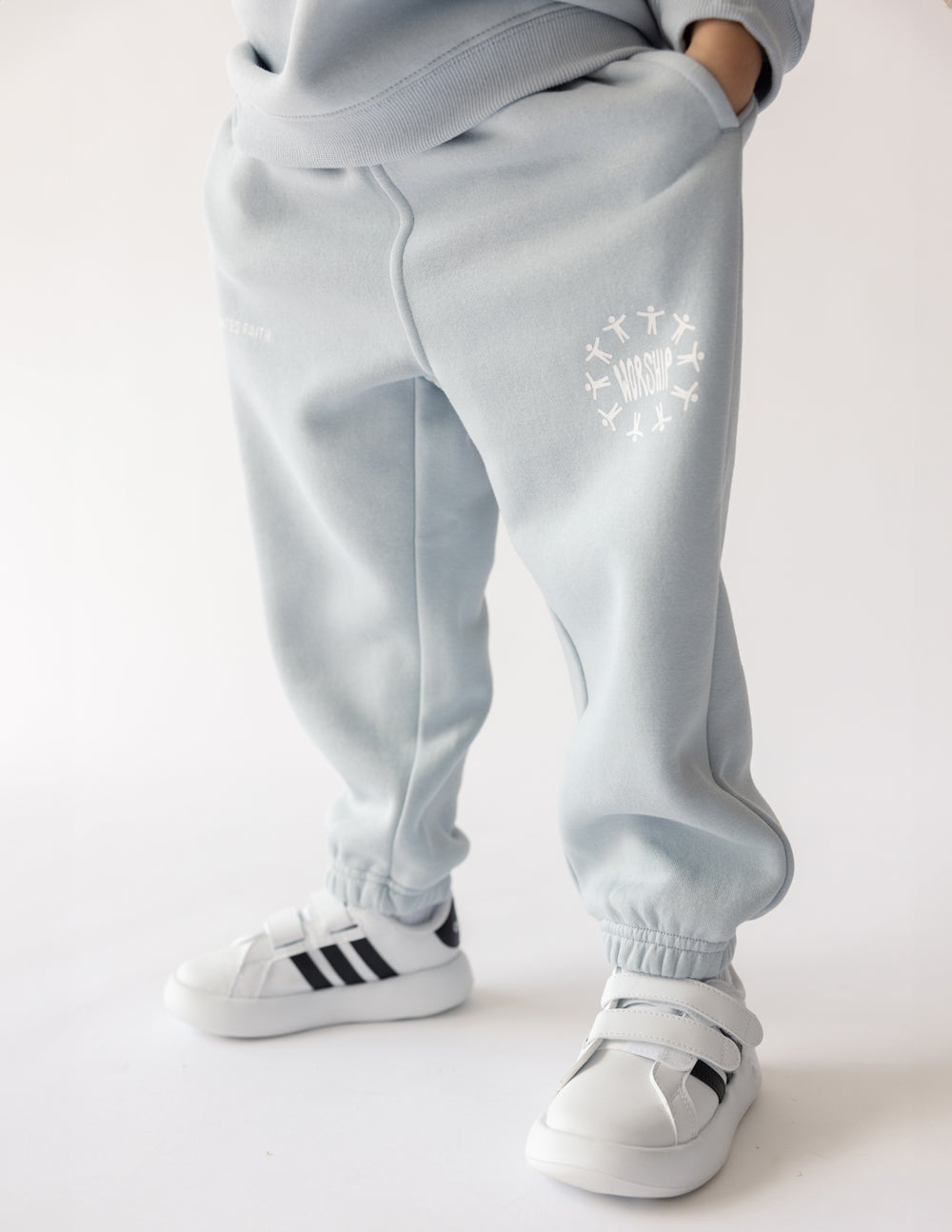 Kids light blue sweatpants with elastic cuffs, seam details, logo graphic