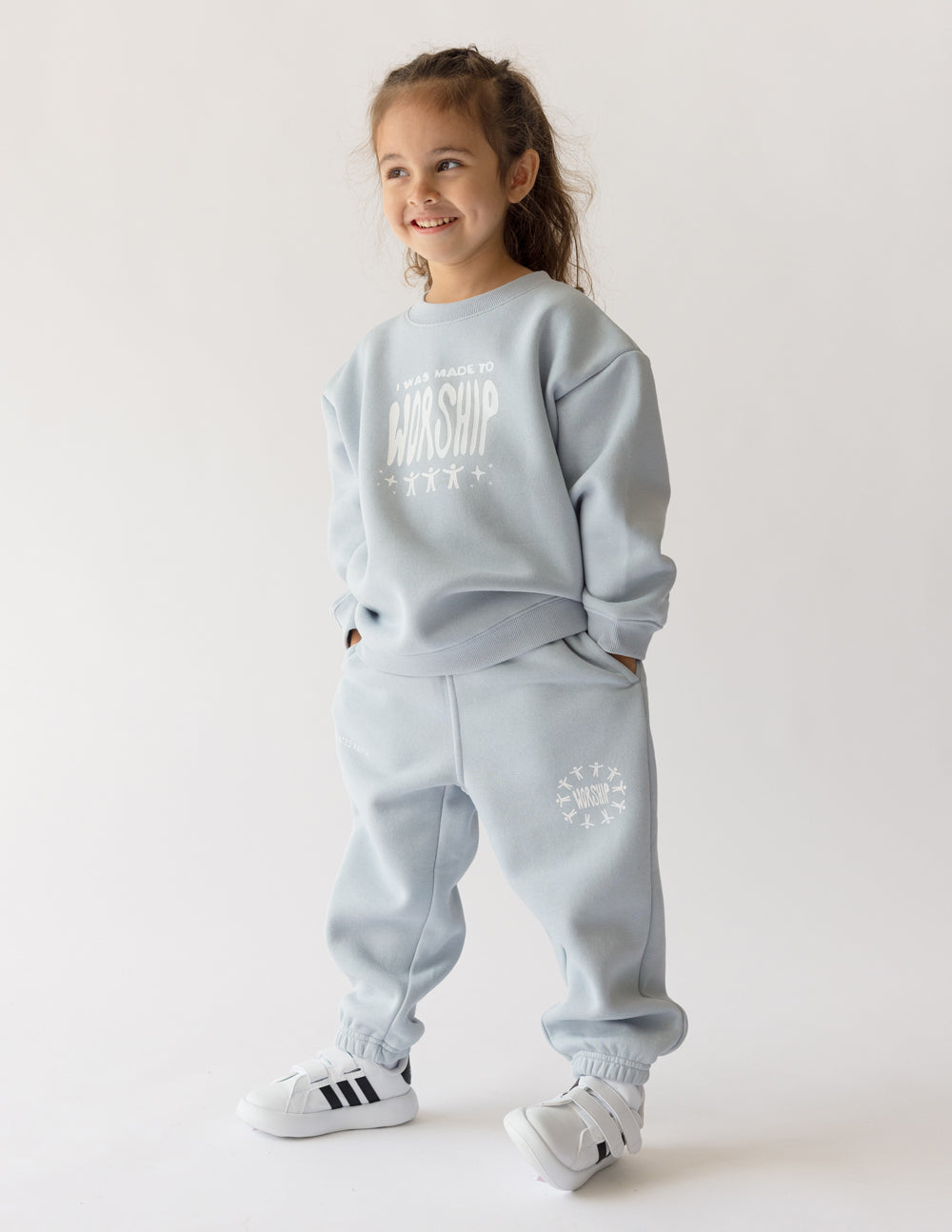 Kids light blue sweatpants with elastic waistband and circular logo graphic
