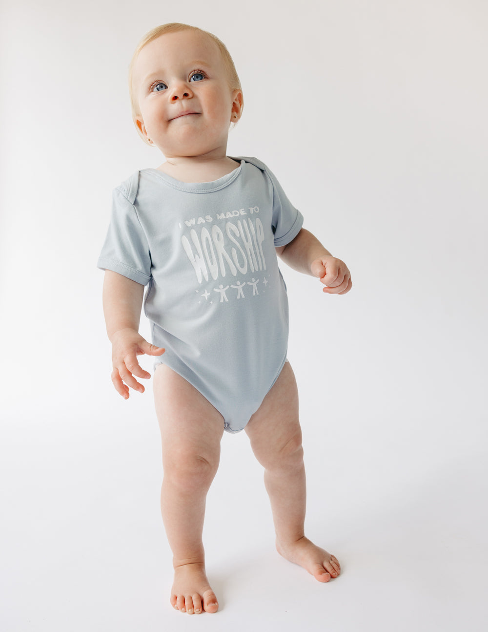 Light gray baby onesie with short sleeves and 'WORSHIP' front print