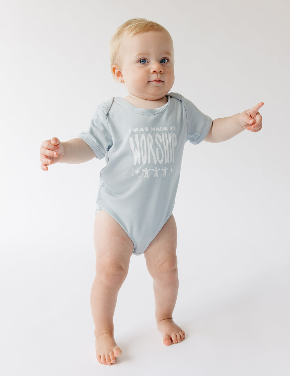 Light gray baby short-sleeve onesie with 'WORSHIP' text graphic