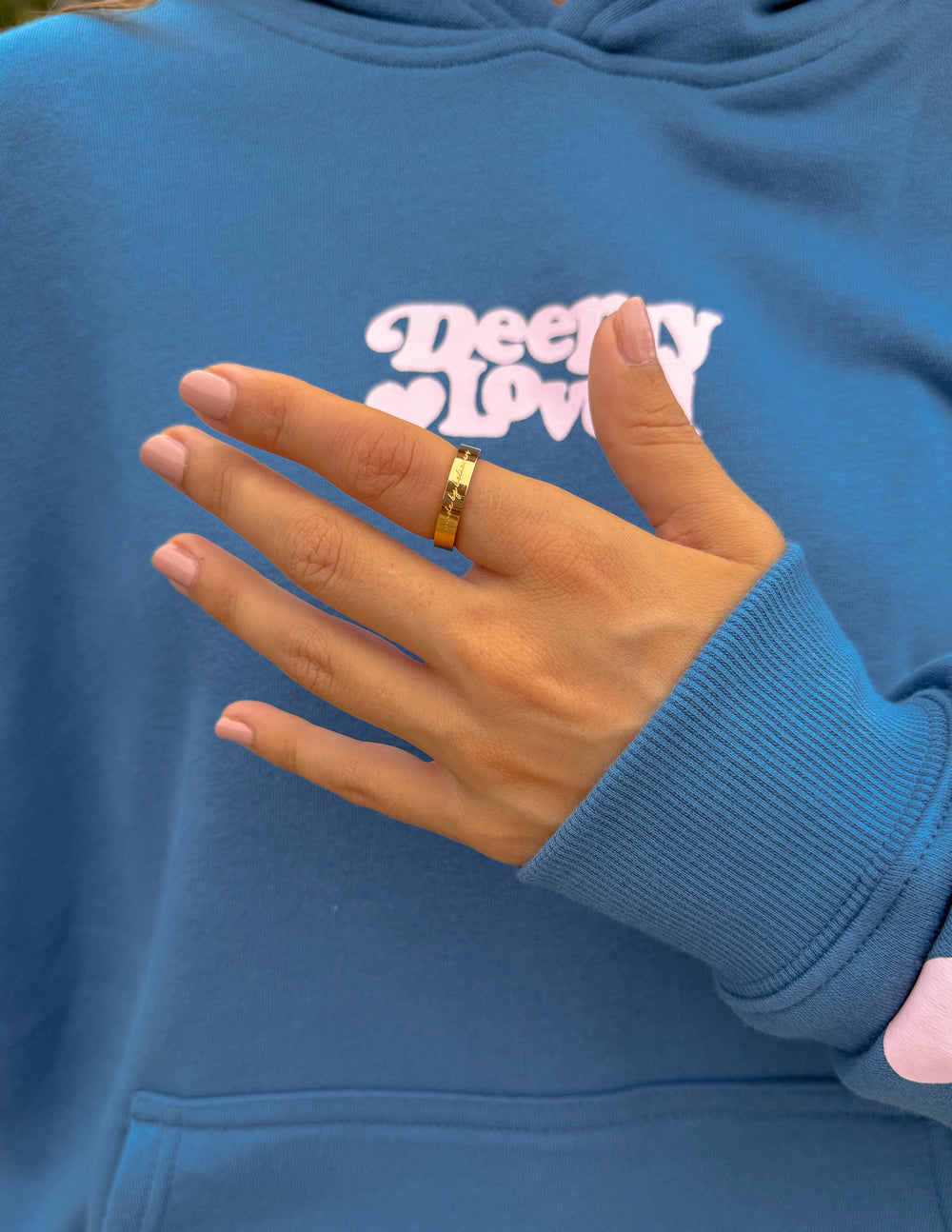 Gold-tone engraved band ring on finger