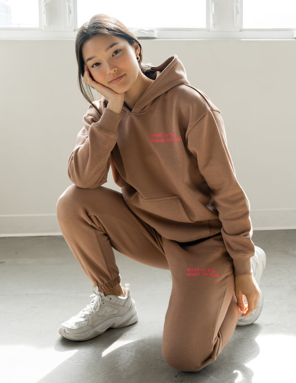 Brown unisex sweatpants with elastic waistband and ankle cuffs, red logo print