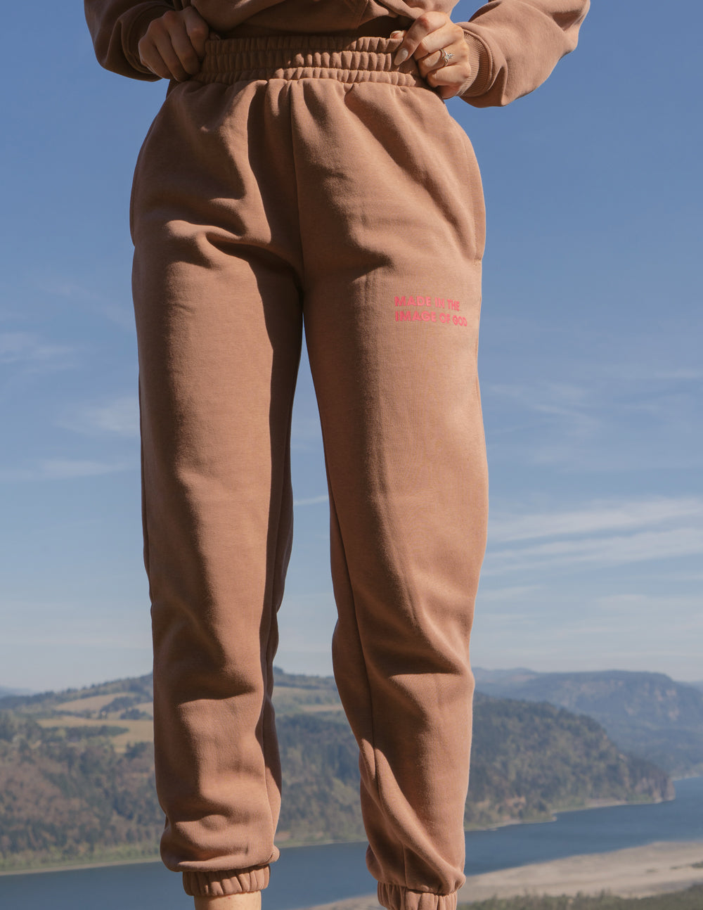 Brown unisex sweatpants with elastic waistband and tapered legs