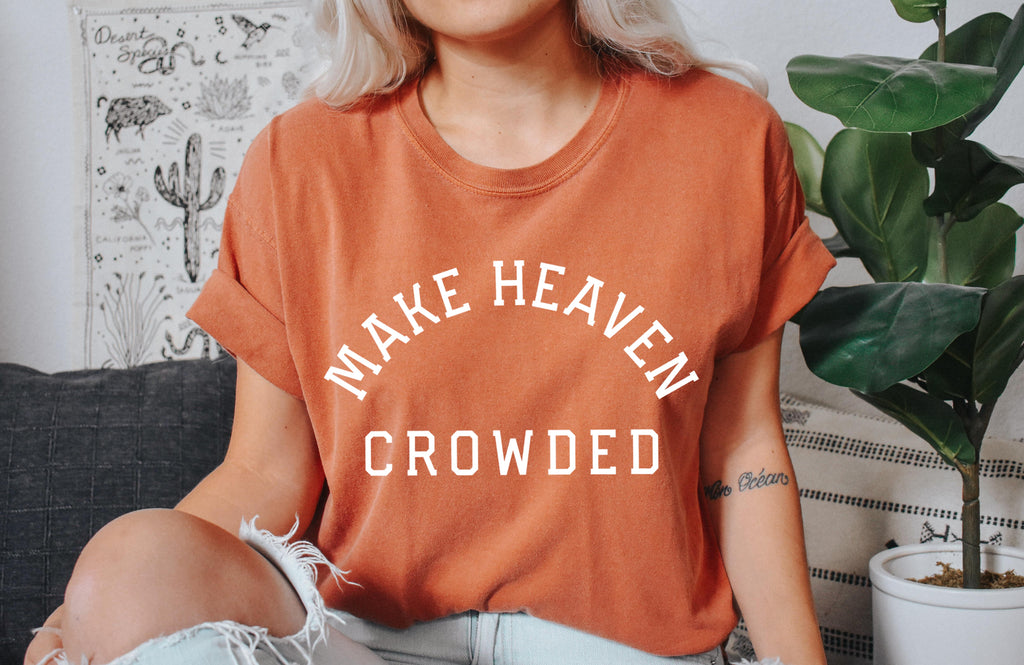 Orange T-shirt with “Make Heaven Crowded” graphic on front