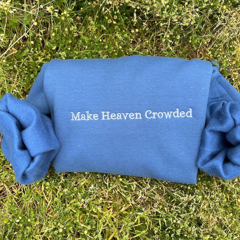 Blue sweatshirt back with embroidered text: Make Heaven Crowded