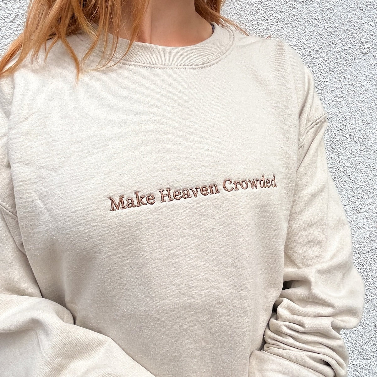 Cream sweatshirt with embroidered text: Make Heaven Crowded